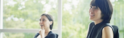 Businesswoman in meeting in conference room holding documents smiling