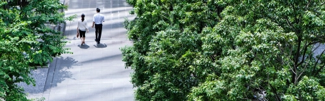 two people walking down a green footpath