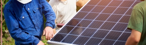 three workers fixing a solar panel