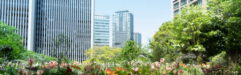 An image of a trees and flowers in front of office buildings 