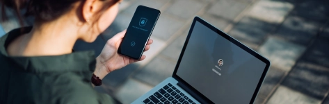 Woman with cell phone and laptop - cybersecurity